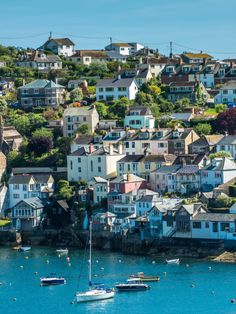 boats floating on the water in front of houses