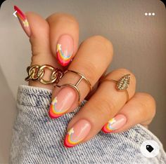 a woman's hand with multicolored nails and rings on her fingers,