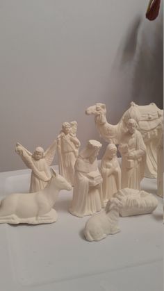 a group of figurines sitting on top of a white table next to each other