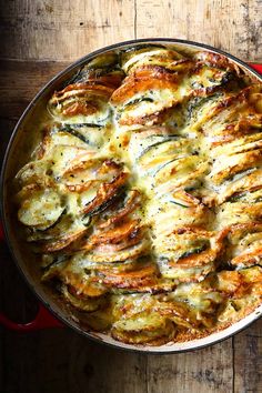 a casserole dish with chicken and spinach in it on a wooden table