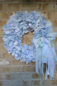 a blue wreath hanging on the side of a brick wall