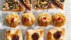 several pastries are arranged on a white tray with red and black toppings in the shape of clown noses