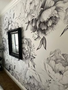 a black and white floral wallpaper with a mirror on the wall next to it