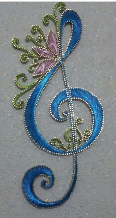 an embroidered music note with blue and green beads