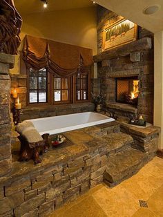 a large bathroom with stone walls and fireplace