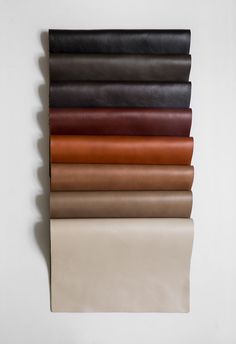 a stack of different colored sheets on top of each other in various sizes and colors