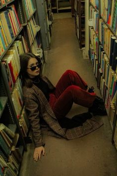 a woman sitting on the floor in a library