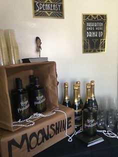 there are bottles and glasses on the table next to each other in front of a sign