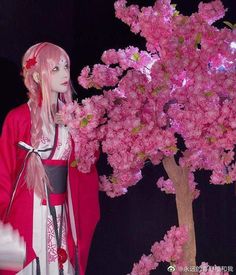 a mannequin is standing next to a pink tree