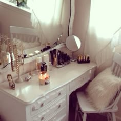 a white desk with a mirror and some candles on it