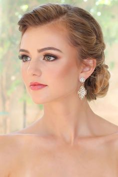 a beautiful woman in a strapless dress with large earrings on her head, looking off to the side