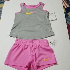 Elastic Waistband Shorts And Snap Closure Pullon Style Tank In Psychic Pink Pink Workout Set For Spring, Pink Workout Sets For Spring, Pink Spring Workout Sets, Playful Nike Sports Sets, Nike Sporty Sets For Playtime, Playful Nike Playwear Sets, Nike Pink Playwear Sets, Pink Stretch Top For Playtime, Playful Pink Nike Sets