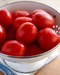 tomatoes in a colander on a wooden table