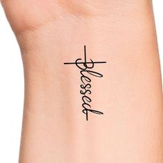 a woman's wrist with a cross tattoo on her left arm and the word jesus written in cursive writing