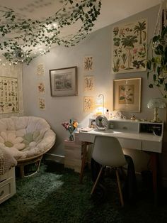 a bedroom with a bed, desk and chair next to a wall covered in pictures