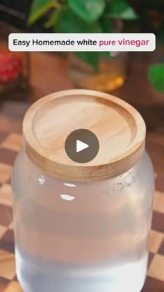 a glass jar with a wooden lid sitting on top of a checkerboard table