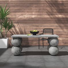 a table with two balls on it in front of a wooden wall and potted plant