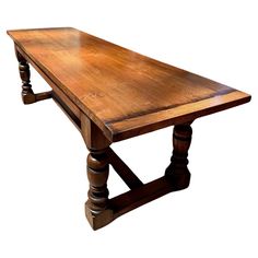 an old wooden table with turned legs and no one sitting at the top or standing up