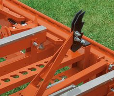 an orange truck with two forks on it's back end and some metal bars attached to the front