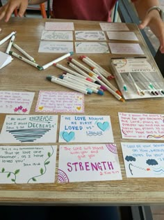 children's handmade greeting cards and crayons on a table with writing