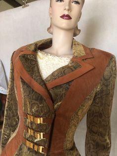 "Veg 80s Cache (label removed) tan snakeskin metallic waisted peplum style jacket 12 Preowned. Condition. 10/10. No issues to note except maybe a press. Style. Typical 80s padded shoulders Fastens with a short black nylon zip and a press stud. Fitted at the waist Peplum flared style at lower edge. Double breasted Fully lined in a rust coloured rayon Long sleeves. Straight edge finish The main fabric used is an amazing bronze, metallic snake print jacket with a slight shimmer. The contrast fabric Tan Removal, Peplum Styling, Birthstone Colors, Peplum Styles, Womens Blazers, Straight Edge, Rust Color, Print Jacket, Historical Clothing