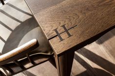 a wooden table and chair with the letter h on it's backrests