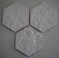 three white hexagonal tiles with flowers on them