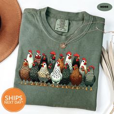 a group of chickens on a green t - shirt with a brown hat next to it