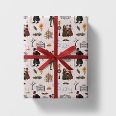 a present wrapped in white wrapping paper with red ribbon and christmas icons on it, sitting on a table