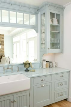 a white sink sitting under a mirror in a kitchen