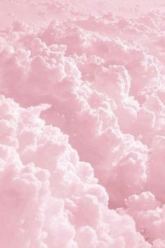 the sky is filled with fluffy clouds and pink hues, as seen from above