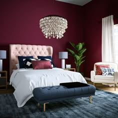 a bedroom with red walls, white bedding and blue carpeted area rugs