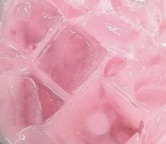 ice cubes in a glass bowl with water and rose milk on the side, top view