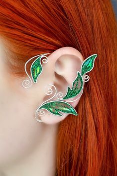 Magical elven ear cuff crafted in silver plated wire and angelina film. The film is very iridescent, so the color may vary depending on viewing angle and lightning. This elf ear cuff is available in 3 colors: emerald green, light-green and golden autumn. You will receive an ear cuff of your chosen colour. The ear cuff is very easy to wear. It is designed to hook over the back of your ear like a Blue Tooth device and can be gently shaped to perfectly fit your ear. No piercing needed. It is very l Ear Cuffs No Piercing, Dragon Ear Cuffs, Leaf Ear Cuffs, Elf Ear, Elf Ear Cuff, Fairy Ears, Ear Cuff Jewelry, Smiley Piercing, Cuff Earring