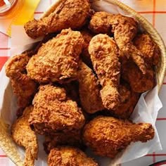 a basket full of fried chicken sitting on top of a table