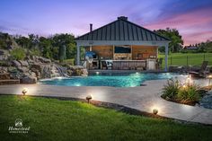 an outdoor pool surrounded by landscaping and lighting