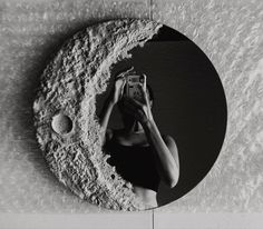 a black and white photo of a woman taking a selfie in front of the moon