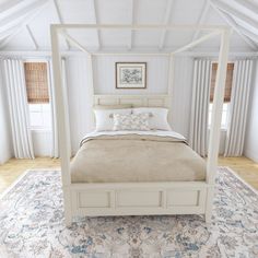 a white bed sitting on top of a rug in a bedroom