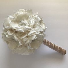 the bridal bouquet is made up of white flowers and burlocked with pearls