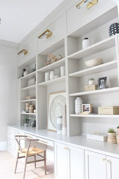 a white bookcase filled with lots of books next to a wooden chair and table