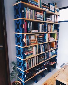 a bookshelf made out of wooden pallets with blue paint on the sides