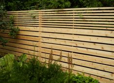 a wooden fence in the middle of some plants