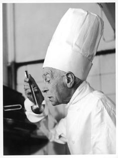 a man wearing a chef's hat and holding a pipe in his right hand