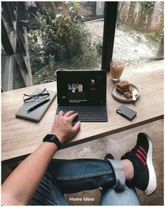 a person sitting at a table with a laptop and cell phone in front of them