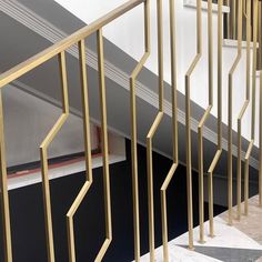 the stairs are made of metal and have gold bars on each handrail, along with marble flooring