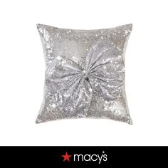 a silver pillow with a large bow on the front and back of it's side