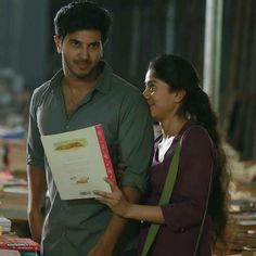 a man and woman standing next to each other in front of boxes with food on them