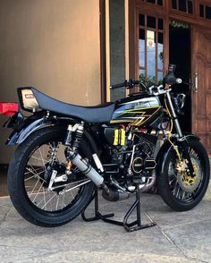 a black and yellow motorcycle parked in front of a building