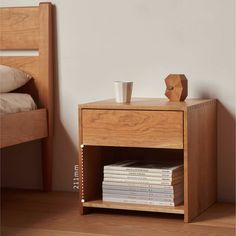 a nightstand with books and a cup on it