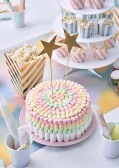 a cake with marshmallows and stars on top is sitting on a table